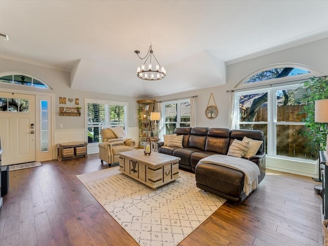 living room with a chandelier, wood-type flooring, and ornamental molding