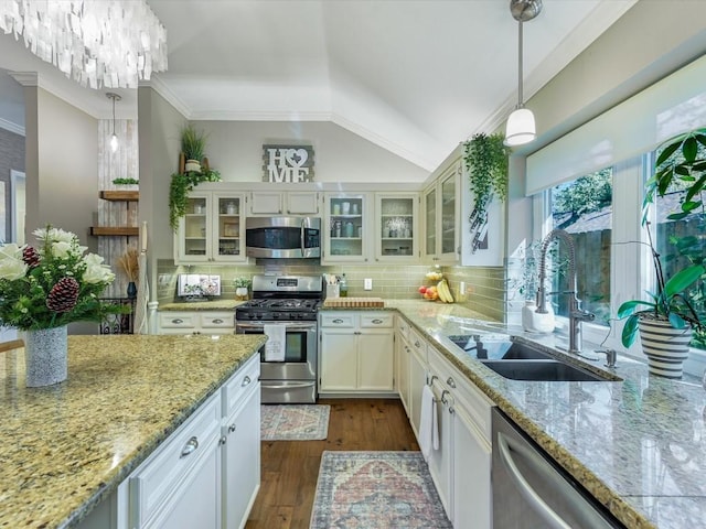 kitchen featuring appliances with stainless steel finishes, white cabinetry, hanging light fixtures, and sink