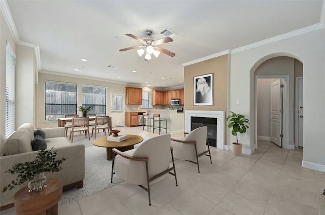 living room featuring ceiling fan, crown molding, and light tile patterned flooring