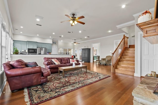 living area featuring stairs, ornamental molding, wood finished floors, and recessed lighting