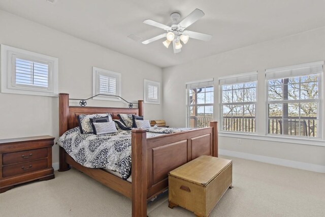 bedroom featuring multiple windows, ceiling fan, and light colored carpet