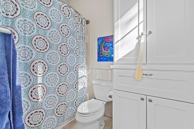 full bathroom with toilet, a wainscoted wall, vanity, tile walls, and tile patterned floors