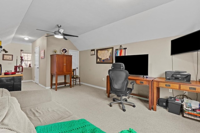 home office with ceiling fan, baseboards, vaulted ceiling, and light colored carpet