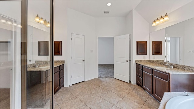 bathroom with vanity, tile patterned floors, and vaulted ceiling