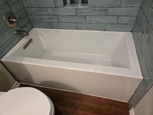 bathroom featuring a washtub and toilet