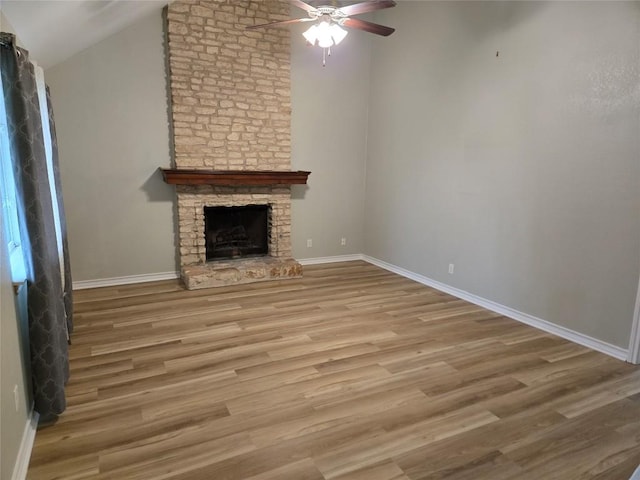 unfurnished living room with ceiling fan, a fireplace, wood-type flooring, and lofted ceiling