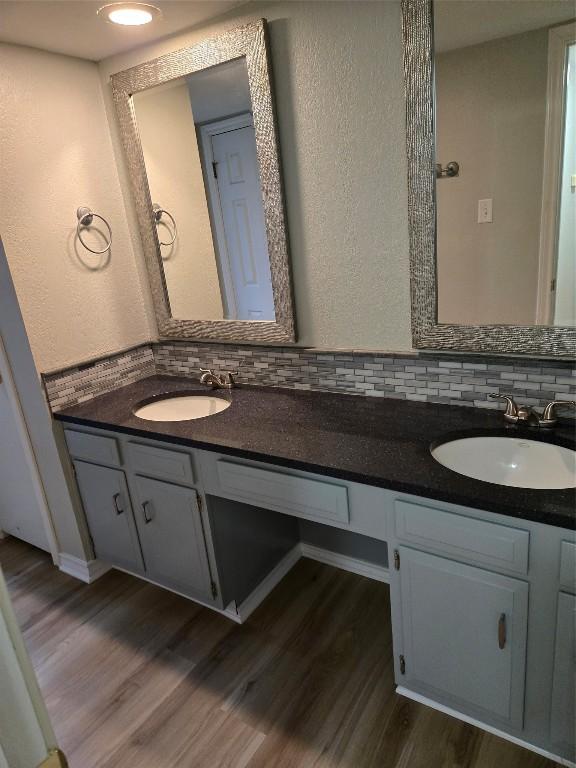 bathroom featuring hardwood / wood-style floors, vanity, and backsplash