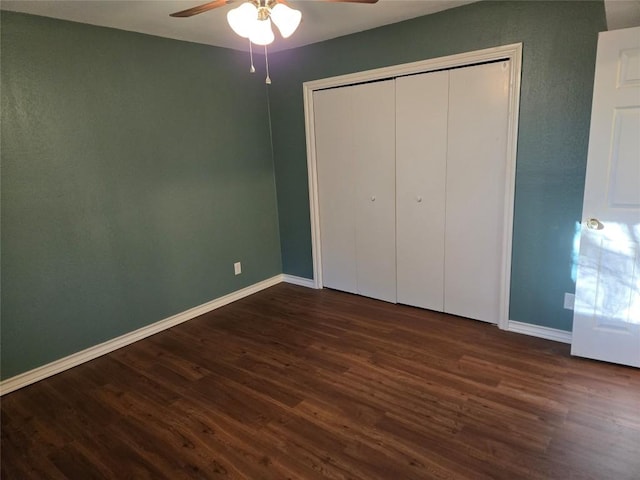 unfurnished bedroom with ceiling fan, a closet, and dark hardwood / wood-style floors