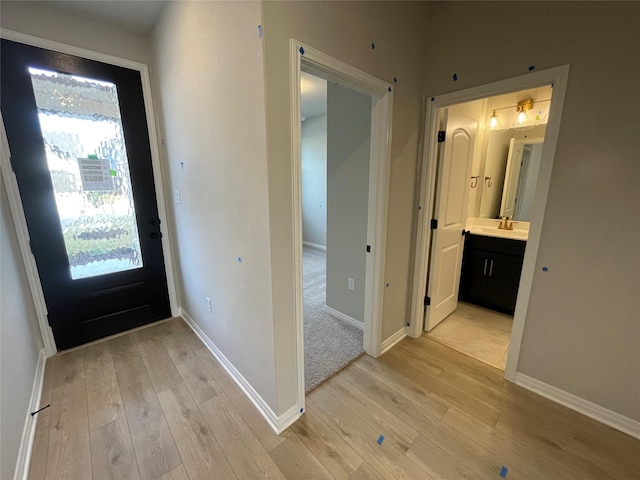 entrance foyer with light hardwood / wood-style floors and sink