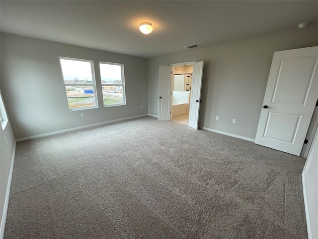 unfurnished bedroom with carpet flooring and ensuite bath