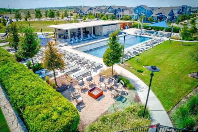 community pool with a yard, a patio, and a residential view