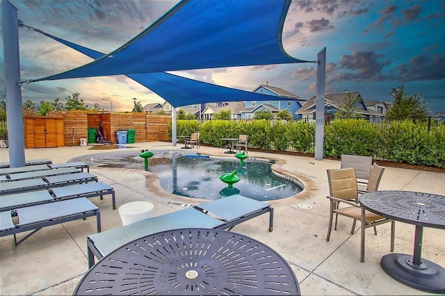 patio terrace at dusk with a fenced in pool