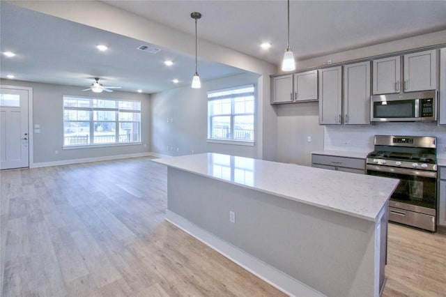 kitchen with visible vents, a healthy amount of sunlight, appliances with stainless steel finishes, light wood-type flooring, and gray cabinets