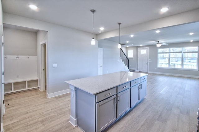 kitchen with baseboards, gray cabinets, a center island, light wood finished floors, and pendant lighting