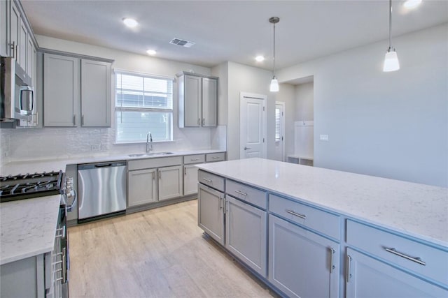 kitchen featuring stainless steel appliances, visible vents, a sink, and gray cabinetry