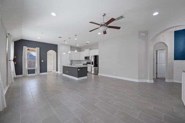 unfurnished living room featuring ceiling fan and sink