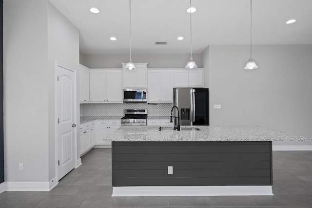 kitchen featuring pendant lighting, a center island with sink, white cabinets, sink, and appliances with stainless steel finishes