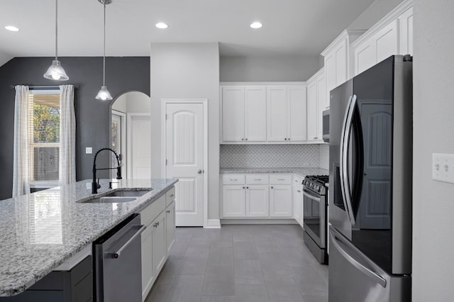 kitchen featuring sink, an island with sink, appliances with stainless steel finishes, tasteful backsplash, and white cabinetry