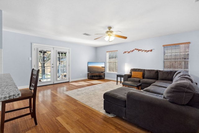 living room featuring french doors, light wood-type flooring, and ceiling fan