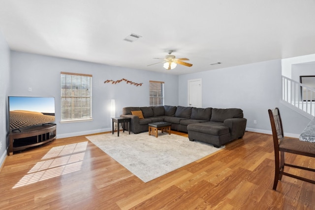 living room featuring light hardwood / wood-style flooring and ceiling fan