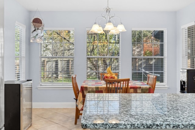 dining area with tile patterned floors, wine cooler, and an inviting chandelier