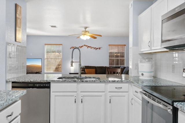 kitchen featuring backsplash, sink, ceiling fan, white cabinetry, and stainless steel appliances