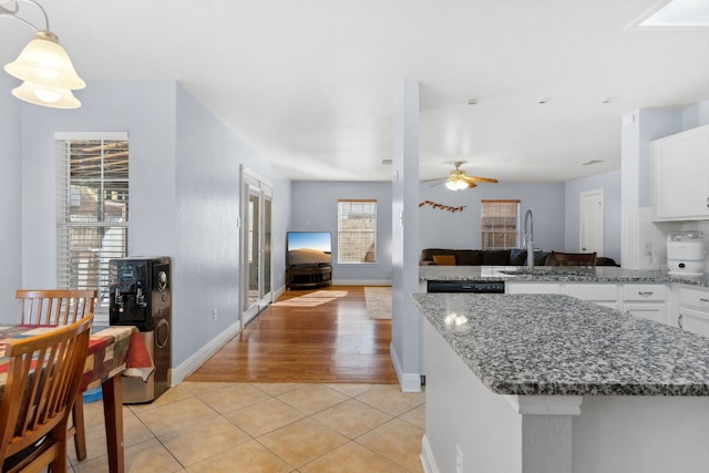 kitchen featuring ceiling fan, a wealth of natural light, white cabinets, and light wood-type flooring