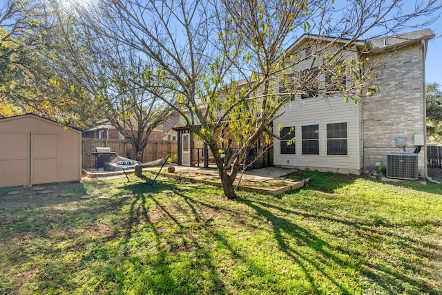 view of yard with a storage unit, cooling unit, and a patio area