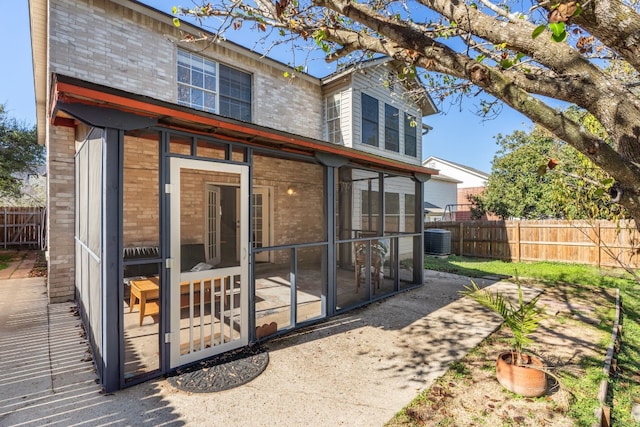 rear view of property featuring central AC and a sunroom