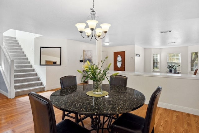 dining area featuring light hardwood / wood-style floors and an inviting chandelier