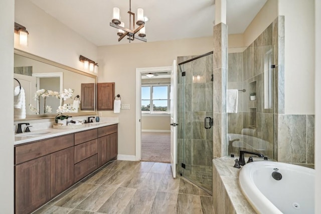 bathroom with vanity, an inviting chandelier, and separate shower and tub