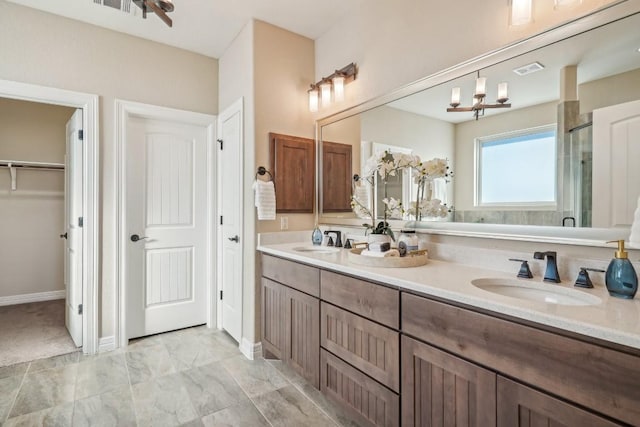 bathroom with vanity, an enclosed shower, and an inviting chandelier