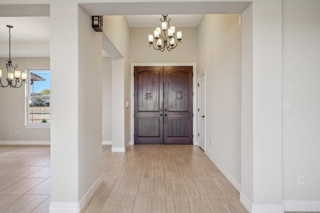 foyer featuring a notable chandelier and baseboards