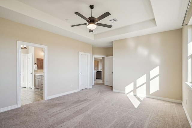 unfurnished room with light colored carpet, a raised ceiling, and ceiling fan