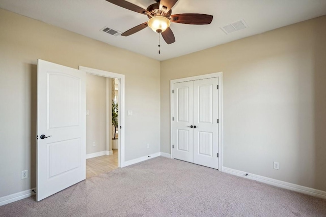 unfurnished bedroom with ceiling fan, a closet, and light carpet