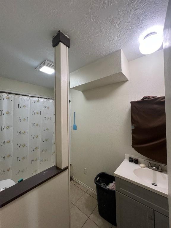 bathroom with tile patterned flooring, vanity, a textured ceiling, and a shower with shower curtain