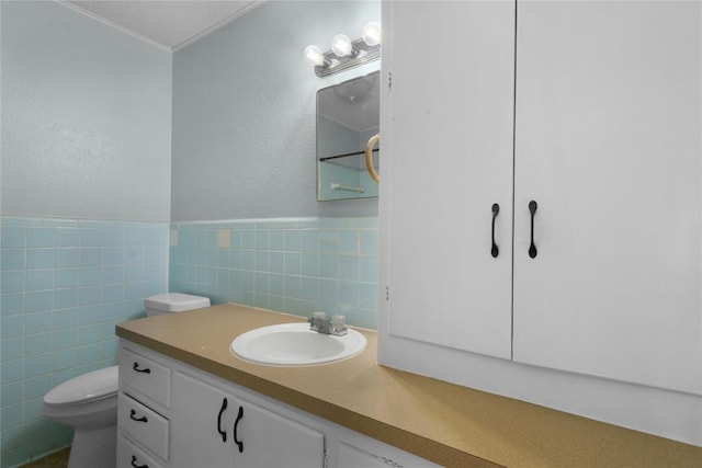 bathroom featuring vanity, toilet, and tile walls