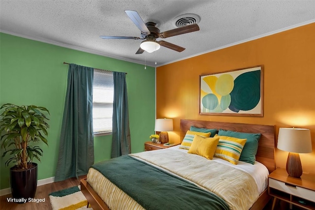 bedroom featuring ceiling fan, ornamental molding, a textured ceiling, and hardwood / wood-style flooring