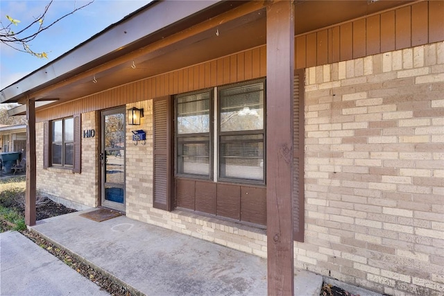 view of exterior entry featuring covered porch