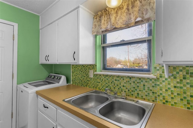 laundry room with cabinets, crown molding, sink, a textured ceiling, and washer / clothes dryer