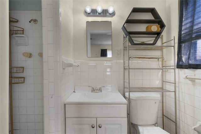 bathroom featuring vanity, toilet, and tile walls