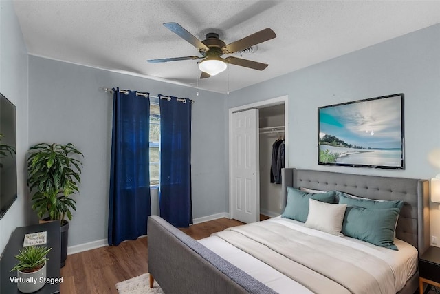 bedroom with hardwood / wood-style floors, a textured ceiling, a closet, and ceiling fan