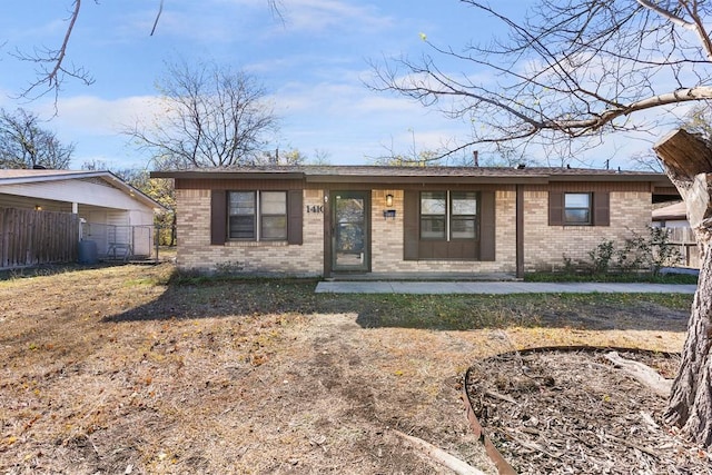 ranch-style home featuring brick siding and fence