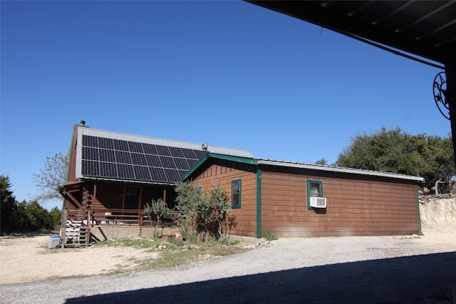 view of home's exterior with cooling unit and solar panels