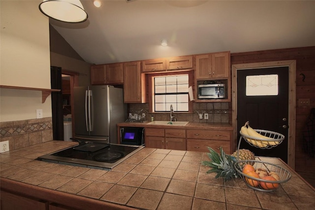 kitchen featuring stainless steel appliances, sink, tile counters, and decorative backsplash