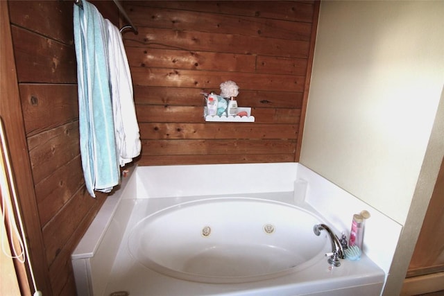 bathroom with a bathtub and wood walls