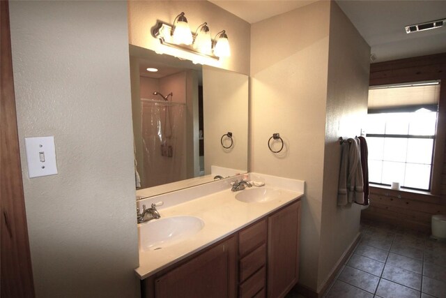 bathroom with tile patterned flooring, vanity, and walk in shower