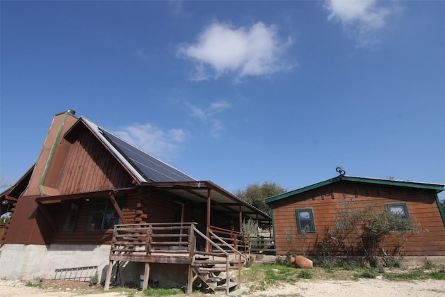 rear view of property featuring an outbuilding