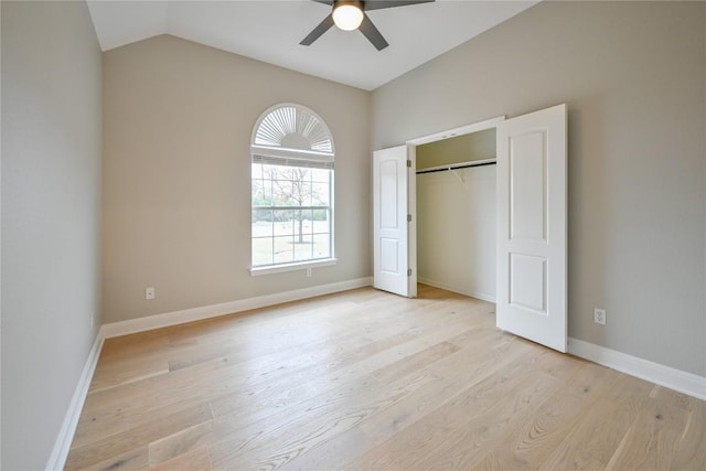 unfurnished bedroom with a closet, ceiling fan, light hardwood / wood-style flooring, and vaulted ceiling