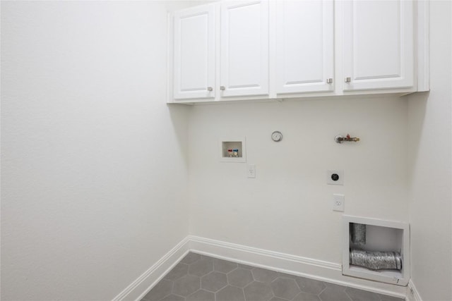 washroom with cabinets, washer hookup, electric dryer hookup, dark tile patterned flooring, and hookup for a gas dryer